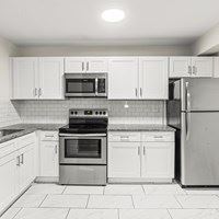 A kitchen with white cabinets and appliances.